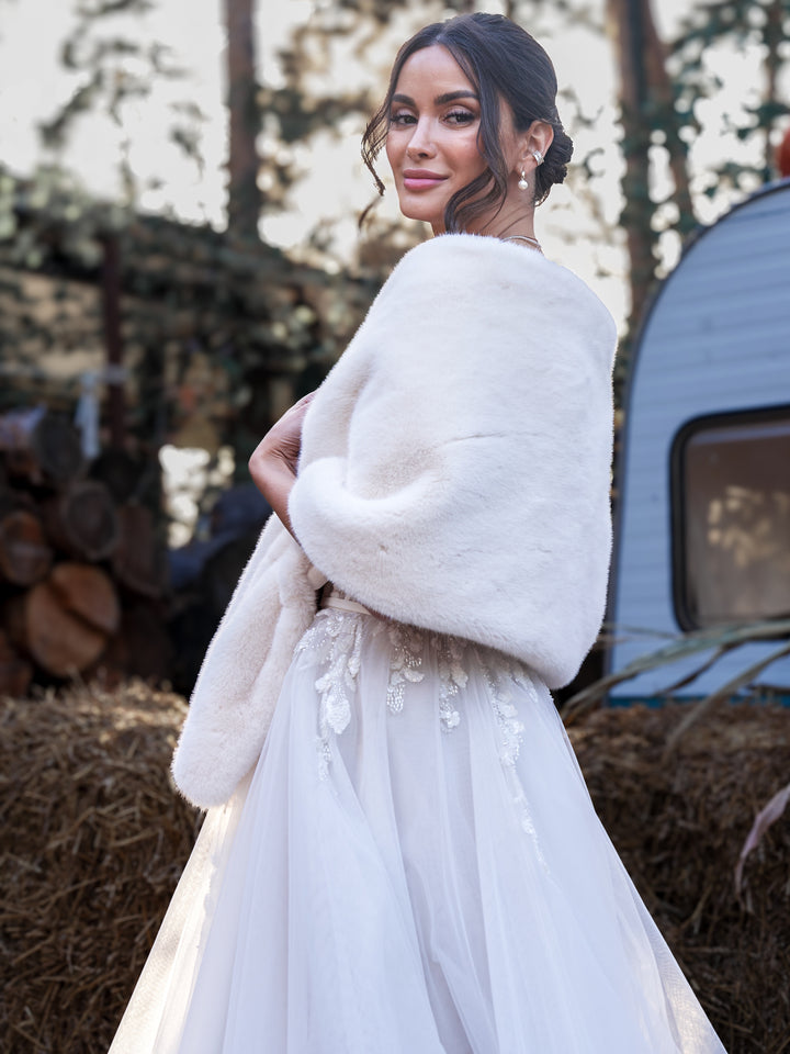 Back view of a bride wearing a white faux fur shawl over her wedding gown