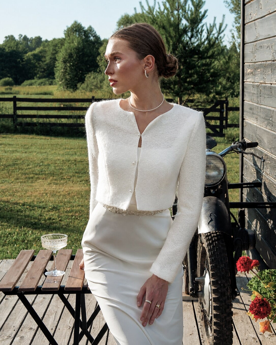 Ivory bridal sweater layered over a satin wedding dress outdoors