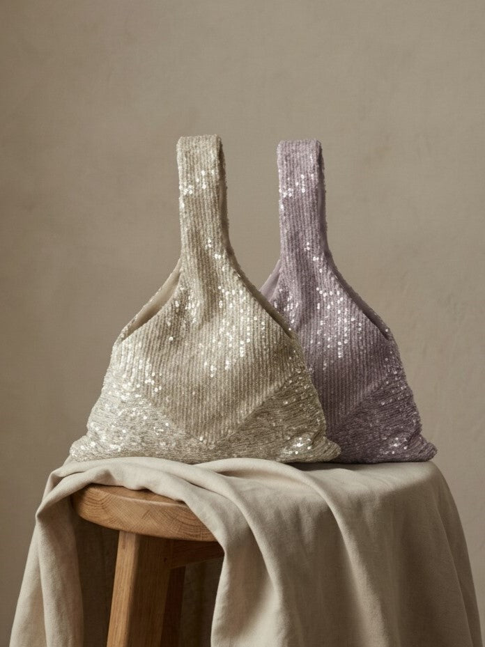 Ivory and lavender sequin clutches displayed together on a draped table