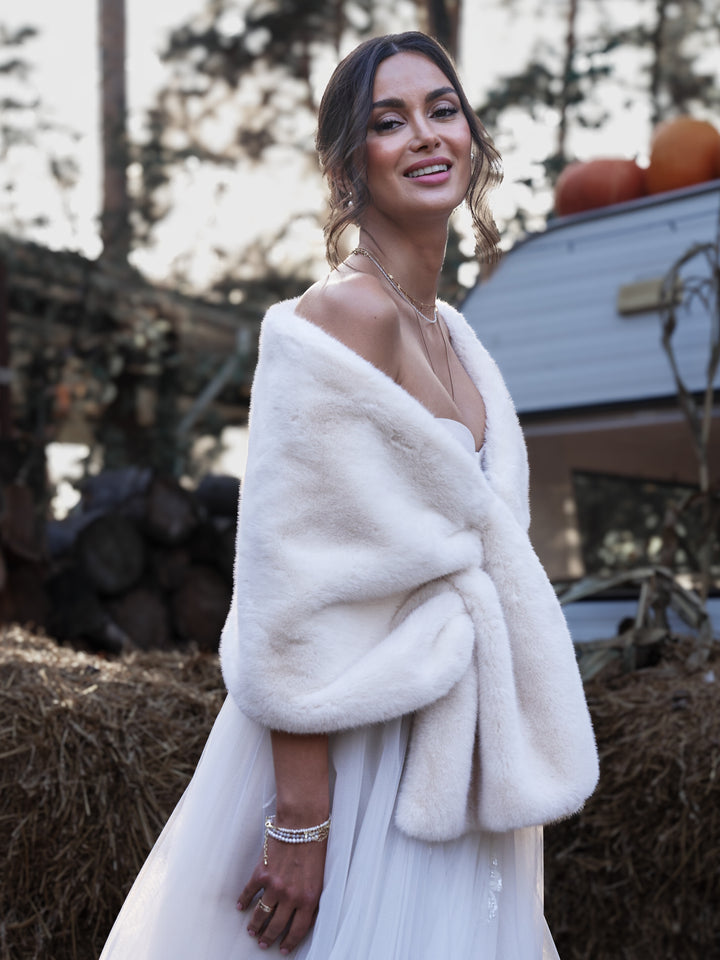 Bride wearing an ivory faux fur stole over an elegant wedding gown