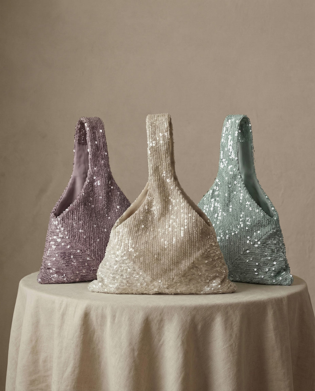 Several sequin bridal bags in lavender, champagne and mint displayed together