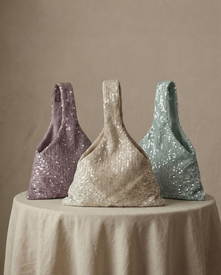 Several sequin bridal bags in lavender, champagne and mint displayed together