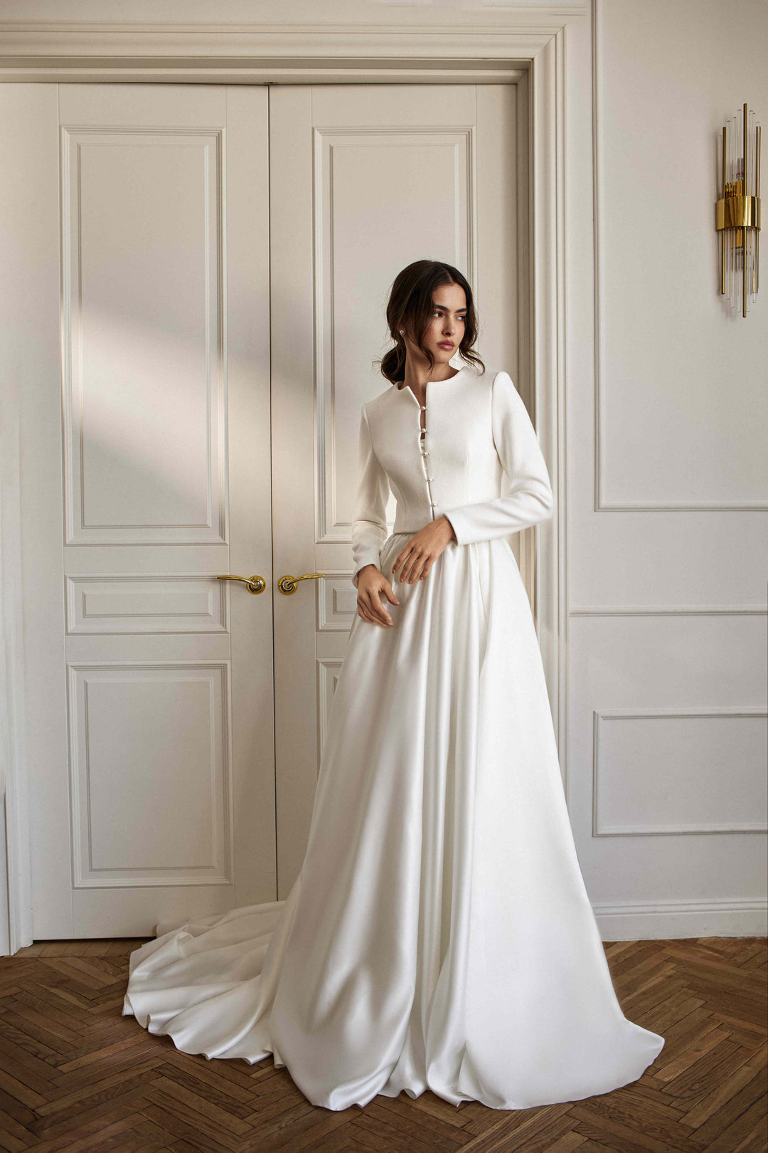 A bride wearing a white wool and cashmere cover-up with a long wedding dress
