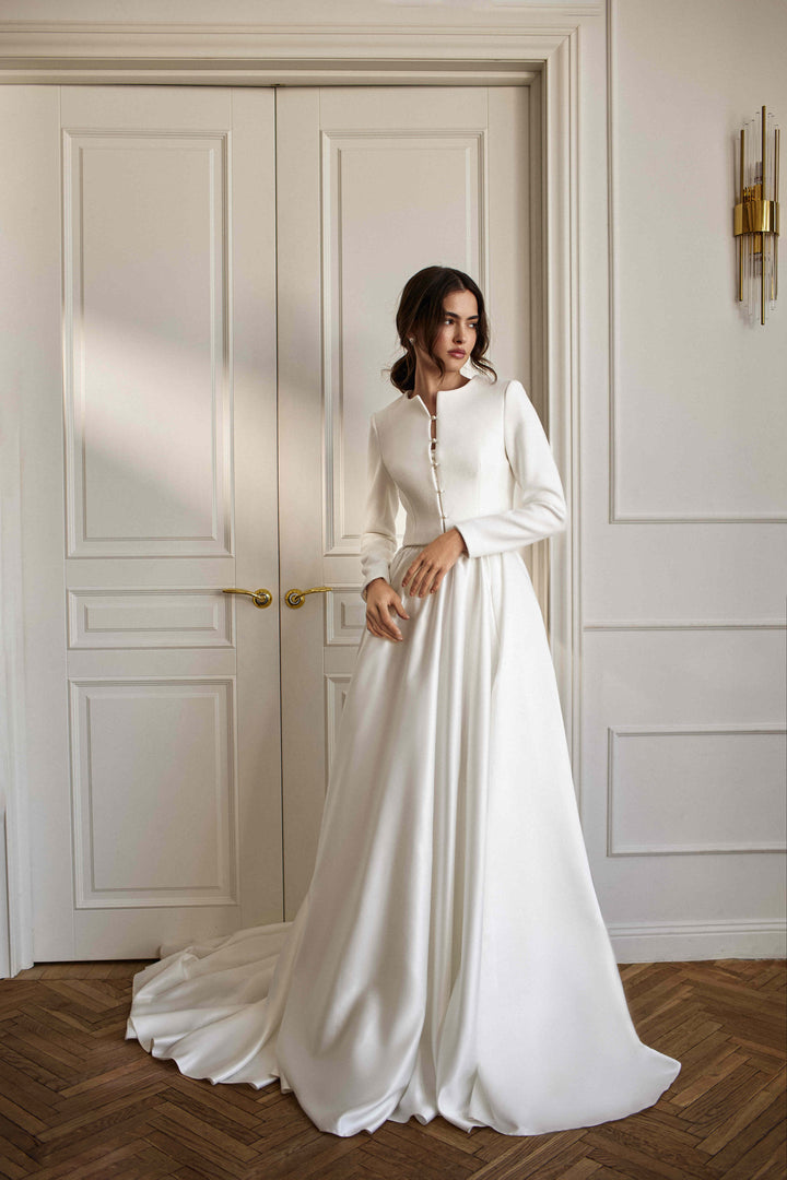 A bride wearing a white wool and cashmere cover-up with a long wedding dress