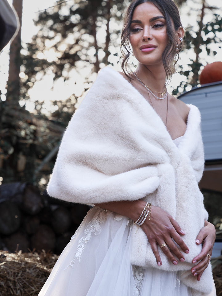 Bride wearing a white faux fur shawl with a long wedding dress