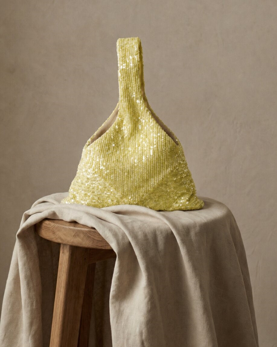 Yellow sequin wedding purse displayed on a neutral fabric surface