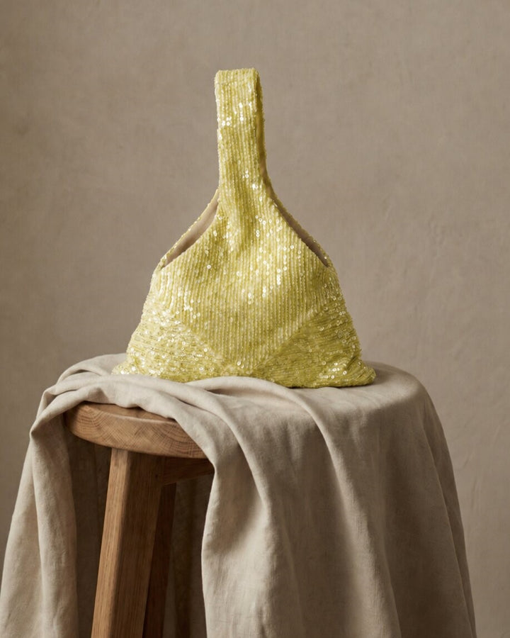 Yellow sequin wedding purse displayed on a neutral fabric surface