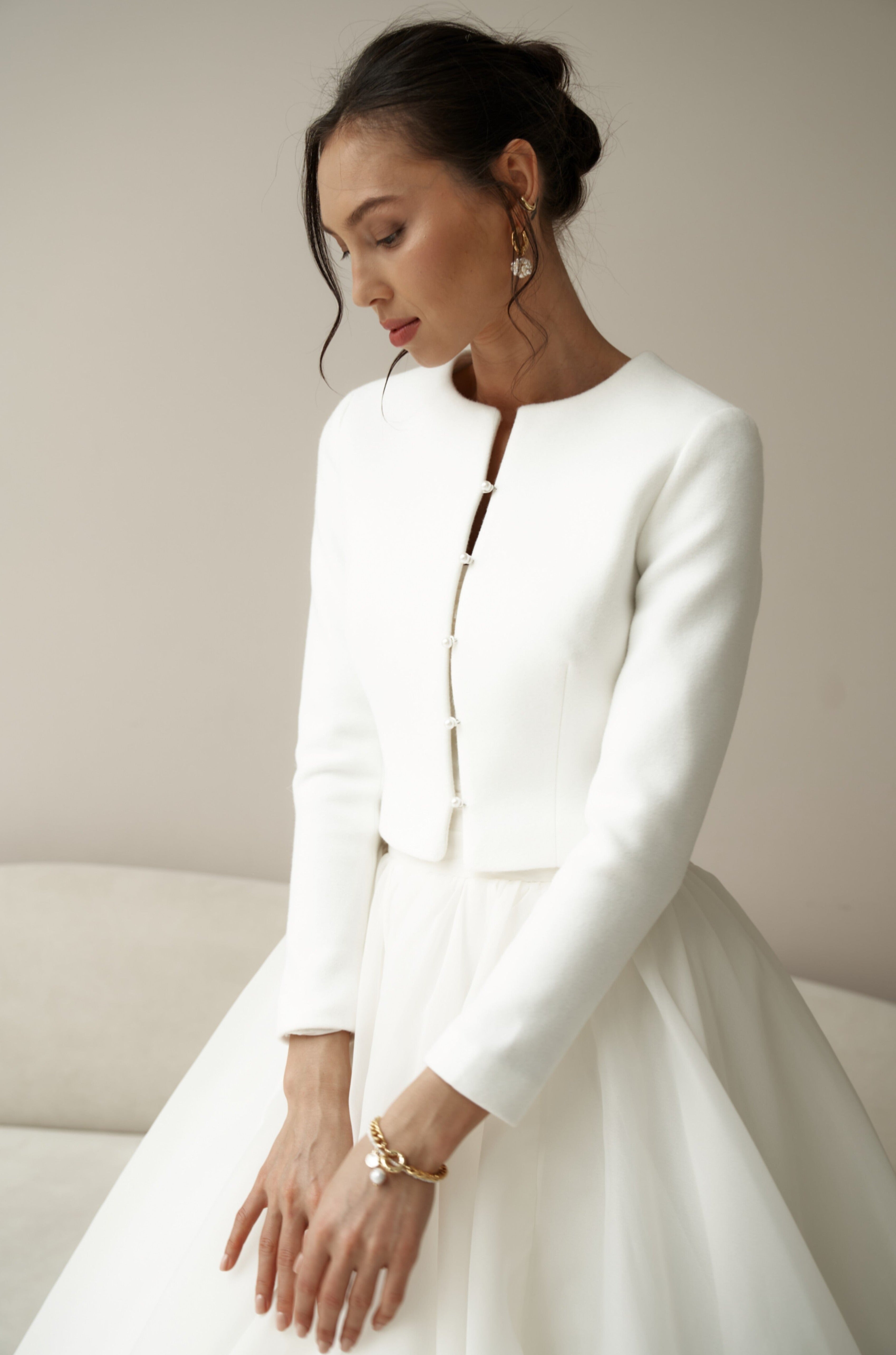 Bridal jacket in classic style with pearl buttons. Wedding coat for br