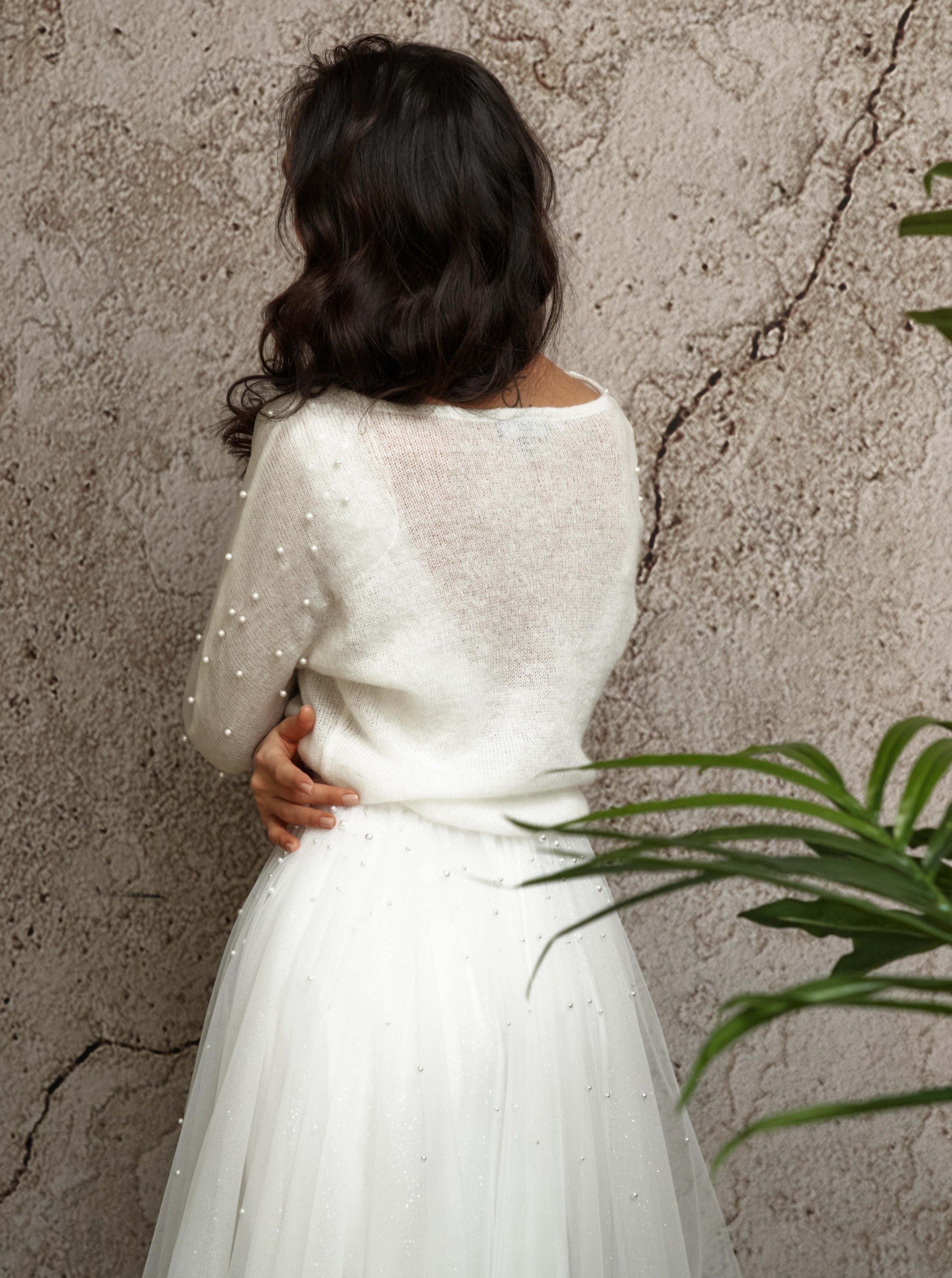 Knitted bridal pullover with decorated sleeves.